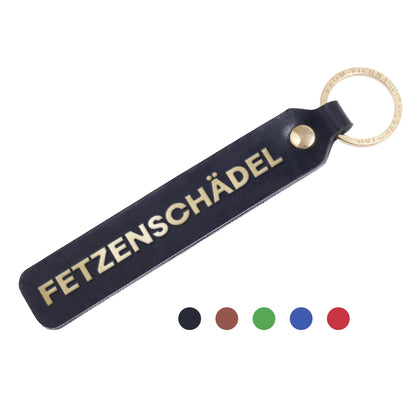 Flatlay, Schlüsselanhänger aus Leder in Schwarz mit Goldprägung 'Fetzenschädel' von LoveTag, handgefertigt in Wien
