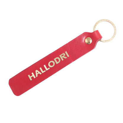 Flatlay, Schlüsselanhänger aus Leder in Rot mit Goldprägung 'Hallodri' von LoveTag, handgefertigt in Wien
