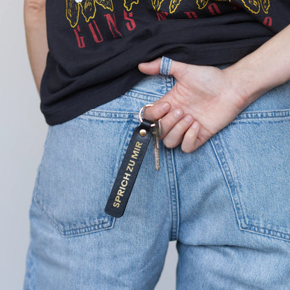 Style Shot, Schlüsselanhänger aus Leder in Schwarz mit Goldprägung 'Sprich Zu Mir' von LoveTag, handgefertigt in Wien