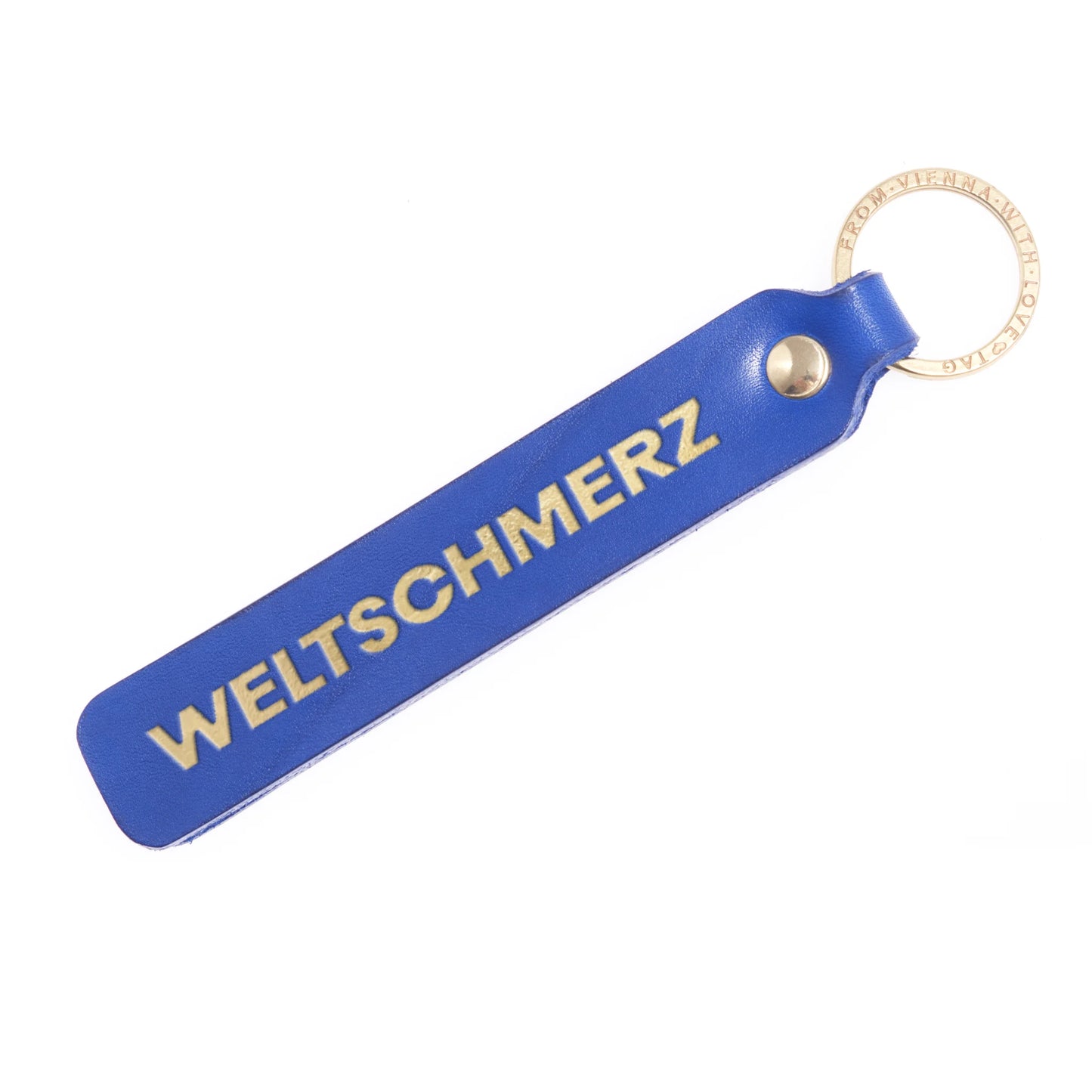 Flatlay, Schlüsselanhänger aus Leder in Blau mit Goldprägung 'Weltschmerz' von LoveTag, handgefertigt in Wien