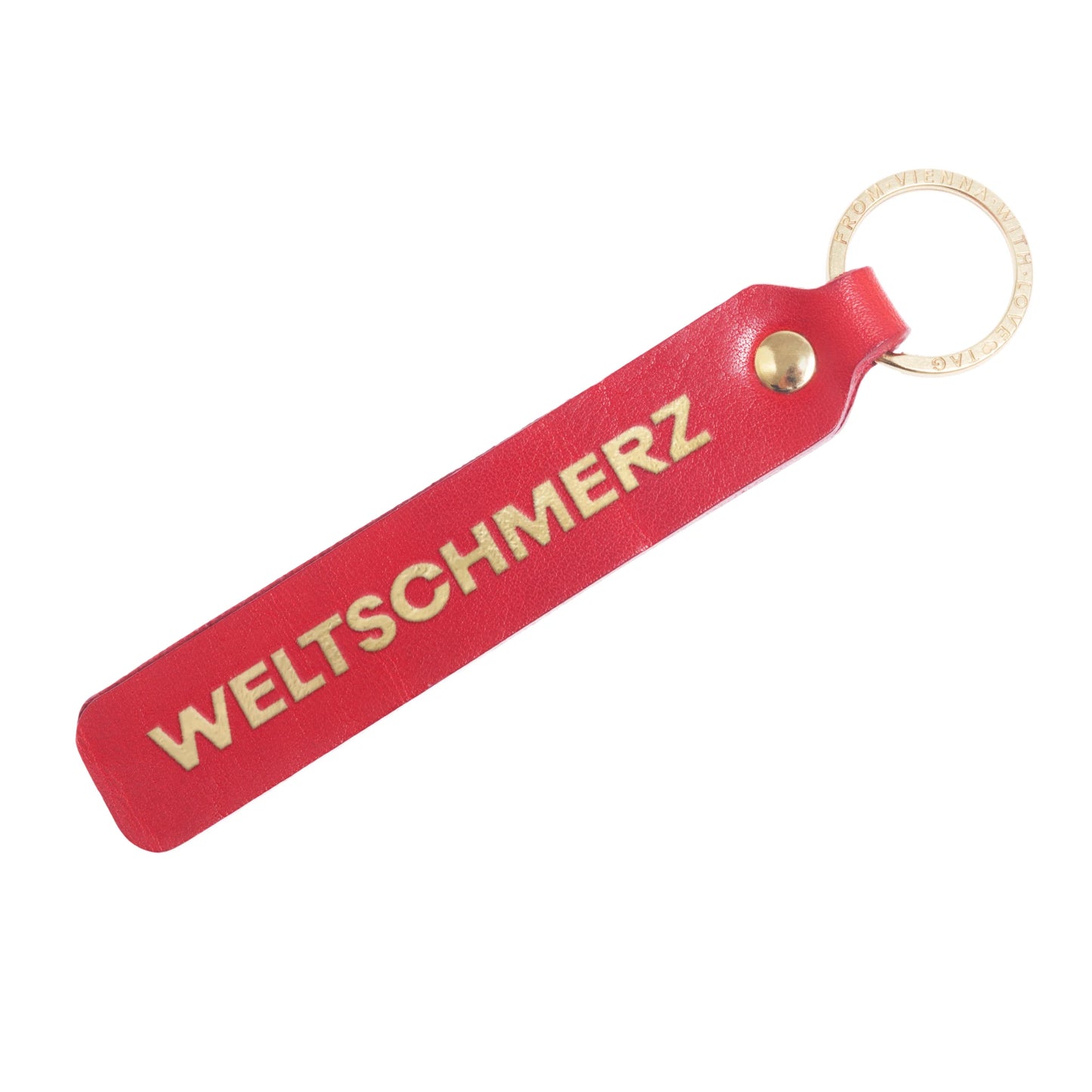 Flatlay, Schlüsselanhänger aus Leder in Rot mit Goldprägung 'Weltschmerz' von LoveTag, handgefertigt in Wien