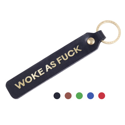Flatlay, Schlüsselanhänger aus Leder in Schwarz mit Goldprägung 'Woke As Fuck' von LoveTag, handgefertigt in Wien