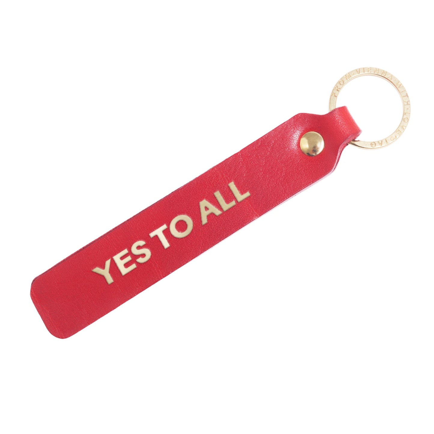 Flatlay, Schlüsselanhänger aus Leder in Rot mit Goldprägung 'Yes To All' von LoveTag, handgefertigt in Wien