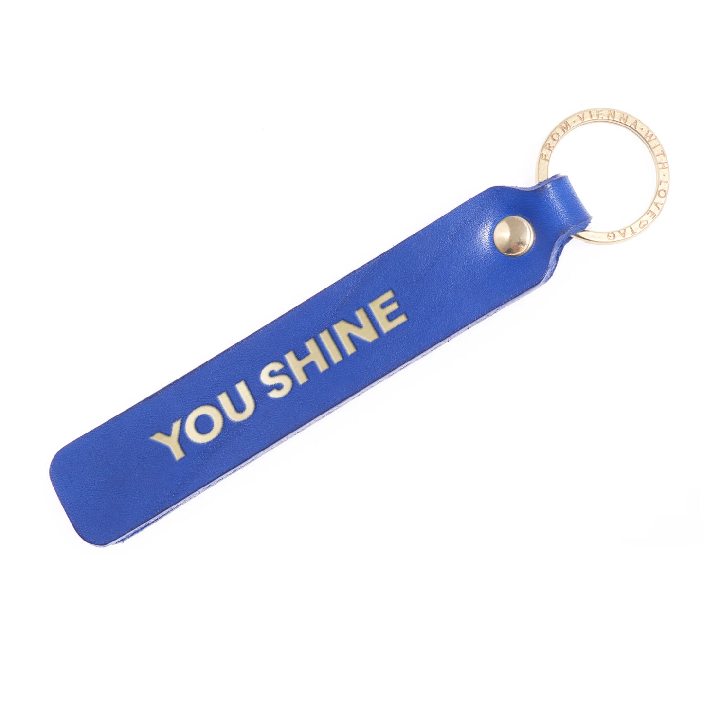 Flatlay, Schlüsselanhänger aus Leder in Blau mit Goldprägung 'You Shine' von LoveTag, handgefertigt in Wien